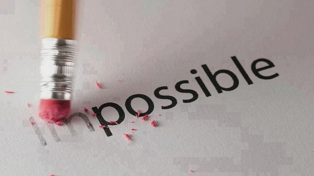 Un crayon avec une gomme efface le mot "impossible" écrit sur une feuille.